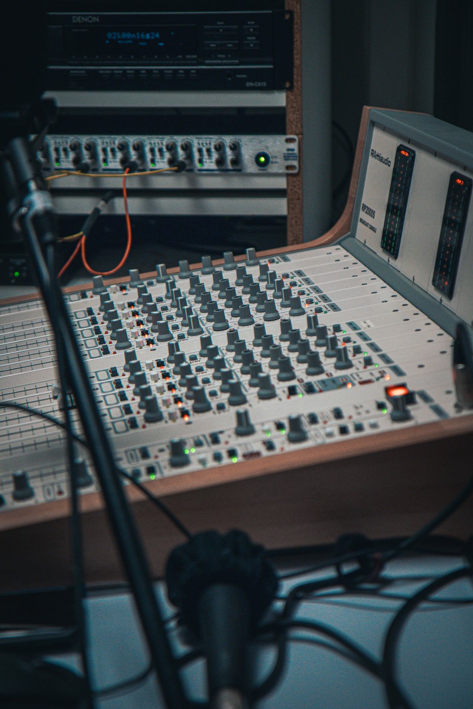 Konsola mikserska audio z suwakami i podświetlanymi przyciskami w studiu.