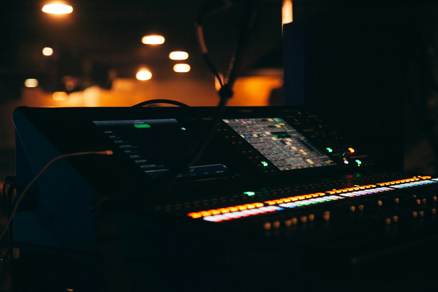 Cyfrowy mikser audio z podświetlanymi przyciskami i ekranami.